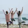 Tres chicas haciendo Yoga en la playa